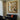 Still life oil painting of daisies in vase with sunlight, coffee and books on table