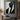 Minimalist oil painting of a black geometric suit silhouette with angular facial planes and diagonal composition on ivory background.
