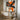 "Orange Burst Abstract" oil painting in black, white, and grey, featuring bold, textured abstract forms dramatically accented with large areas of vibrant orange/red.