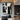 Abstract oil painting with irregular black geometric shapes including triangles, squares, and polygons on white canvas, creating high-contrast dynamic composition.  