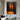 Abstract oil painting of two glowing orange human silhouettes standing vertically against a dark charcoal background with mirrored reflections.