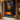 Abstract oil painting of two glowing orange human silhouettes standing vertically against a dark charcoal background with mirrored reflections.