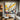Abstract expressionist oil painting with energetic yellow, black, and red strokes on white canvas