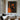 Abstract oil painting of a bold orange female silhouette with minimalist curves against a deep charcoal-black background.