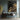 Abstract oil painting of flowing golden waves with metallic texture, crashing against a stark black canvas background, minimalist seascape with dynamic brushstrokes.