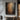 Textured impasto oil painting with layered charcoal black and sienna brown earth tones, raw brushstrokes revealing ochre and white pigment undertones.