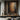 Textured impasto oil painting with layered charcoal black and sienna brown earth tones, raw brushstrokes revealing ochre and white pigment undertones.